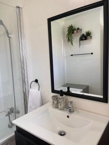 a bathroom with a white sink and a mirror at The Willow Suite - Larola 35 in Clarens +4 photos