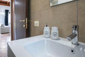 a bathroom sink with two bottles on top of it at Morning Glory in Fiumicino +13 photos