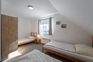 a bedroom with two beds and a window at Apartmány Happy Klínovec in Loučná pod Klínovcem