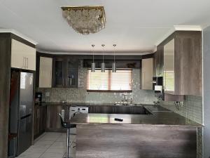 a kitchen with wooden cabinets and a large kitchen island at Cozy two bedroom apartment with Study in Sandton