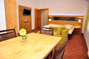 Zimmer mit einem Tisch und einem Sofa sowie einem Schlafzimmer in der Unterkunft Gästehaus Gritscher in Josefsthal