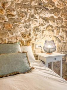 a bedroom with a stone wall with a bed and a table at Casa Rural Sant Roc in Murla