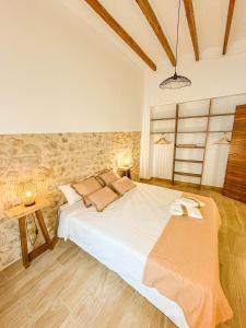 a bedroom with a large white bed and two lamps at Casa Rural Sant Roc in Murla +41 photos