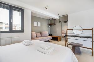 a bedroom with a white bed and a living room at Athens Genesis Luxury Suites By SEM in Athens