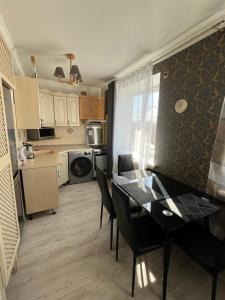 a kitchen and dining room with a table and chairs at Central Cosy-Turistu Mitne in Daugavpils