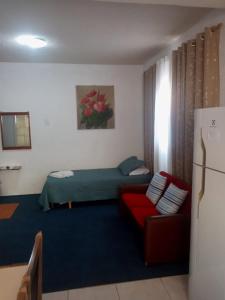 a living room with a couch and a bed at Kitnet Privativa no Portal de Campos do Jordão in Campos do Jordão