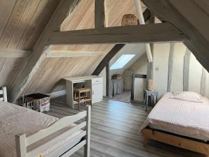 a attic bedroom with a bed and a desk at A la campagne in Saint-Calez-en-Saosnois