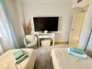 Televízia a/alebo spoločenská miestnosť v ubytovaní Casares Beach Golf Apartment With Private Garden Direct Pool Access