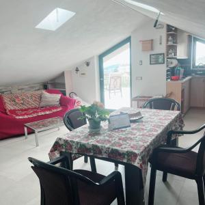 Una sala de estar con una mesa y sillas y un sofá. en Chez Sylviane Alloggio turistico in campagna vicino al mare, en Spigno Saturnia