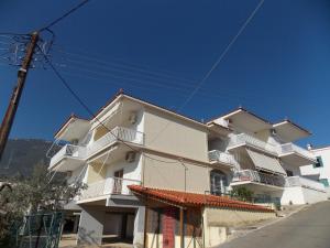 - un bâtiment blanc avec des balcons blancs dans une rue dans l'établissement Zavitsa, à Xiropigado