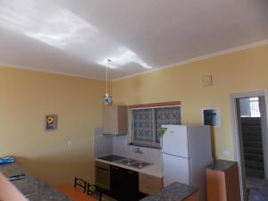 - une cuisine avec des murs jaunes et un réfrigérateur blanc dans l'établissement Zavitsa, à Xiropigado
