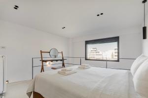 a white bedroom with a bed and a mirror at Athens Genesis Luxury Suites in Athens
