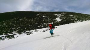 a person is skiing down a snow covered slope at Etna GloB&B Hiking in Zafferana Etnea