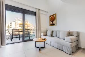a living room with a couch and a table at Athens Genesis Luxury Suites By SEM in Athens