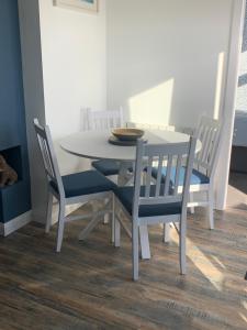 - une table à manger blanche avec 4 chaises et un bol dans l'établissement Beach Buoys holiday chalet Close to the dog friendly beach, à Bridlington 5 autres photos