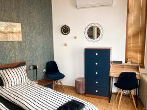 1 Schlafzimmer mit einem Bett, einem Schreibtisch und 2 Stühlen in der Unterkunft Two Bedroom Apartment - Alexandrovska - Top Location - Central Bus, Train and Marine Stations, next to Sea Garden and Beach in Burgas City