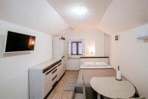 una pequeña habitación con una cama y una mesa en EMA HOUSE, en Zadar