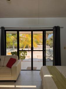 a living room with a couch and a large window at Beachfront department Celestun in Celestún