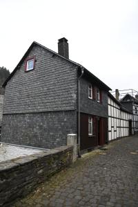 un grande edificio in mattoni con porte rosse accanto a una strada di mattoni di Knusperhäuschen a Monschau