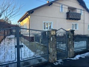a gate in front of a house with snow at OliverHouse in Gura Humorului