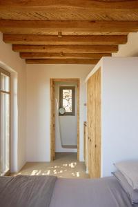 a bedroom with a bed and a wooden ceiling at Great View, Tiny Hill-top house in Rámos +10 photos