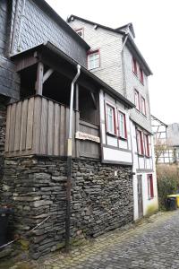 un edificio con una facciata in pietra con un muro in pietra di Knusperhäuschen a Monschau