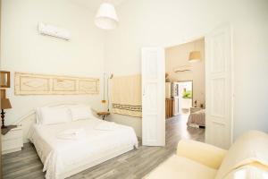a white bedroom with a bed and a couch at OURANIAS HOUSE in Kalymnos