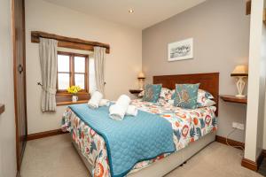 a bedroom with a bed and a window at Ystumgwern Luxury Barn Conversions in Dyffryn