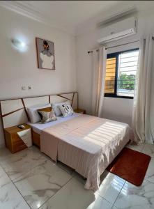 Un dormitorio con una cama y una ventana en Home ADOK, en Abiyán