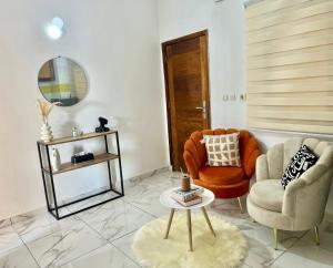 Una sala de estar con dos sillas y una mesa. en Home ADOK, en Abiyán