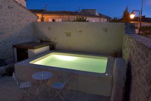 a swimming pool with two chairs and a table at Maison de Charme, patio et piscine, wifi in Aujargues