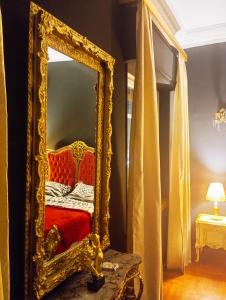 a mirror sitting on a table next to a bed at IRIS baroque apartment in Eleusis
