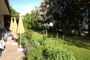 un jardín con flores y sombrillas en un patio en Hotel Schaumburg, en Bad Pyrmont
