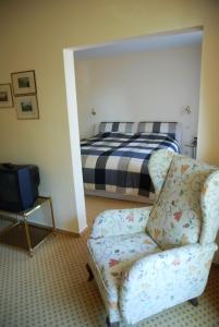 uma sala de estar com uma cadeira e uma cama em Hotel Schaumburg em Bad Pyrmont