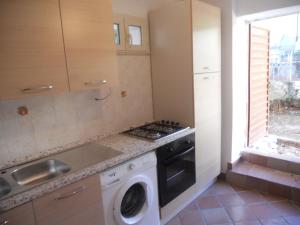 a kitchen with a stove and a washing machine at Villa Eleonora in Formia
