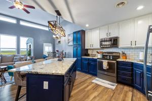 a kitchen with blue cabinets and a living room at Black Hills Barndo-Hot Tub & Massage Chair in Hermosa