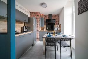 a kitchen with a table and chairs in a room at Le Cocon des Volcans #Confort#Parking in Clermont-Ferrand
