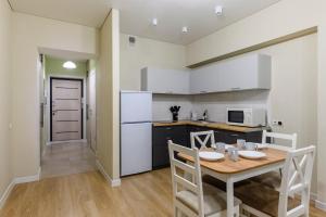a kitchen with a wooden table and a dining room at One Bedroom Apartment Near Arbat In The Golden Square of Almaty in Almaty +11 photos