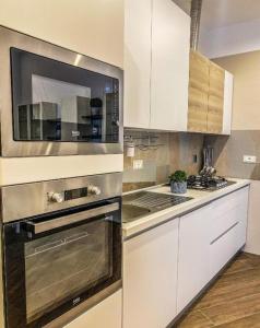 a kitchen with white cabinets and a stove top oven at Loft K Apartment- Manfredi Homes & Villas in Manfredonia