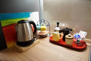 a tea kettle and cups on a tray on a table at House 105 Suite Apartment in Perugia