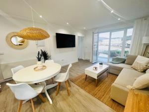 una sala de estar con una mesa y un sofá en Villa Turquesa B, en Viveiro