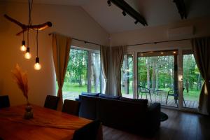 a living room with a dining room table and a couch at Bijūnų Šilas in Žaugėdai