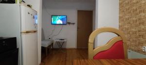 a living room with a refrigerator and a tv on the wall at Home-Vasva and Hazim in Ćukovi