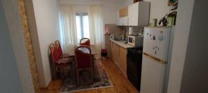 a kitchen with a refrigerator and a table and chairs at Home-Vasva and Hazim in Ćukovi