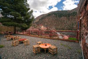 a group of tables and chairs with a view of a mountain at Tayda Guest House in Azdal