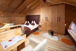 a room with two beds and a woman sitting on the floor at Hotel Apartment Das Au- Gut in Hallein