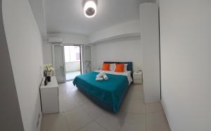 a bedroom with a bed with a blue blanket and orange pillows at Bella Tao Apart in Taormina