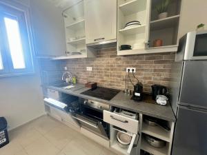 a kitchen with white cabinets and a stainless steel refrigerator at City Centre Piac Flat in Debrecen