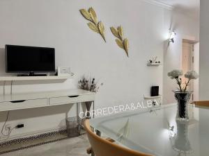 salon z telewizorem na białej ścianie w obiekcie Habitaciones Casa Sevillana Centro w Sewilli
