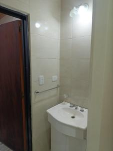 a white bathroom with a sink and a mirror at Complejo EL MIRADOR in Olavarría
